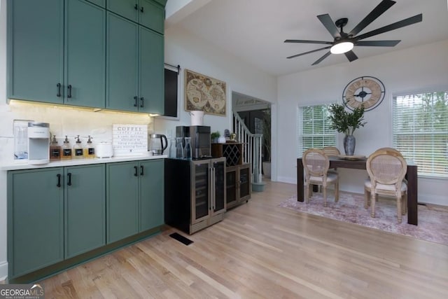 4492 Bryten Dr, Douglasville, GA 30135 - kitchen with green cabinets, a ceiling fan, tasteful backsplash, wine cooler, and light wood-type flooring