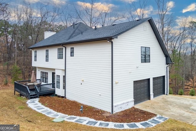 4492 Bryten Dr, Douglasville, GA 30135 - view of property exterior with a wooden deck, a chimney, a garage, a shingled roof, and concrete driveway