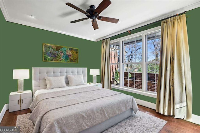 bedroom with ceiling fan, dark hardwood / wood-style flooring, and crown molding