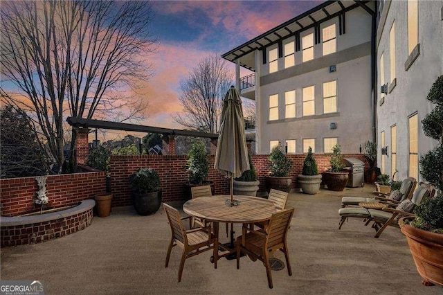 patio terrace at dusk featuring grilling area