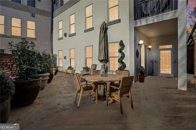 patio terrace at dusk featuring a balcony