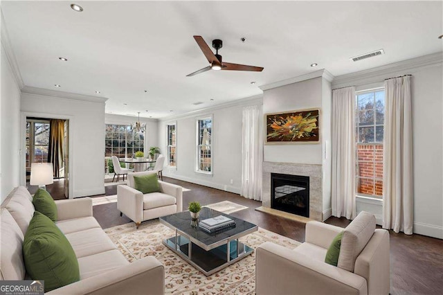 living room with a premium fireplace, crown molding, ceiling fan, and hardwood / wood-style flooring