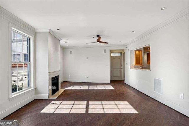 unfurnished living room with ceiling fan, crown molding, and dark wood-type flooring