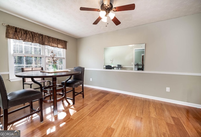 dining room with a textured ceiling, light hardwood / wood-style flooring, and ceiling fan