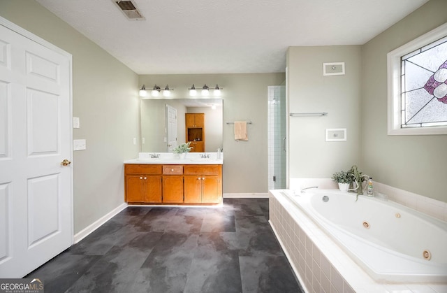 bathroom with vanity, independent shower and bath, and a textured ceiling