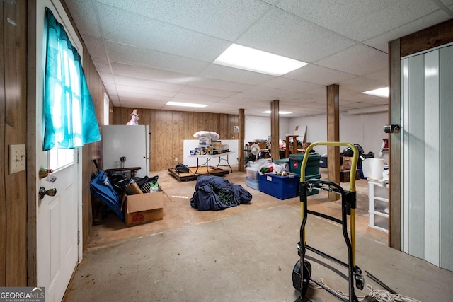 basement with wooden walls and a drop ceiling