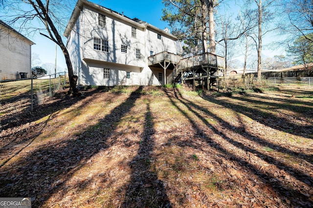 rear view of house with a deck and a lawn