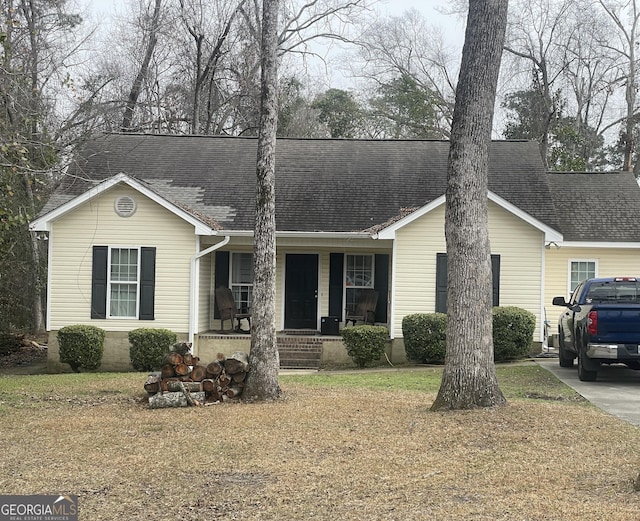 ranch-style home featuring a porch and a front lawn