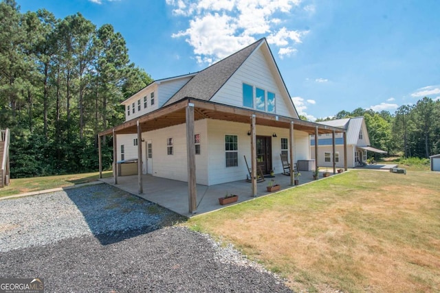 rear view of house with a lawn and a patio