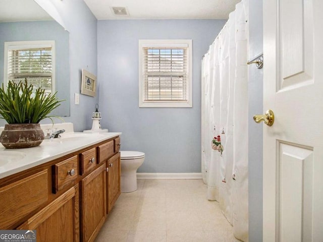 bathroom featuring a shower with shower curtain, vanity, and toilet