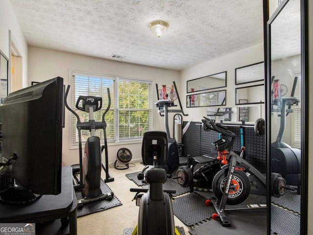 exercise room featuring a textured ceiling