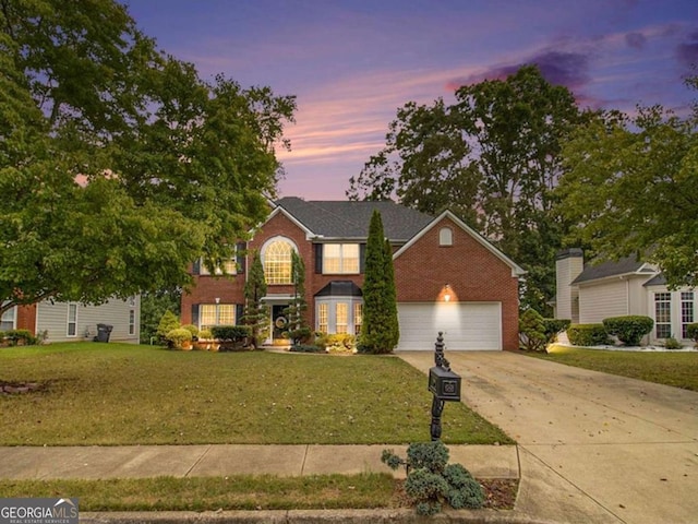 view of front of home with a lawn and a garage