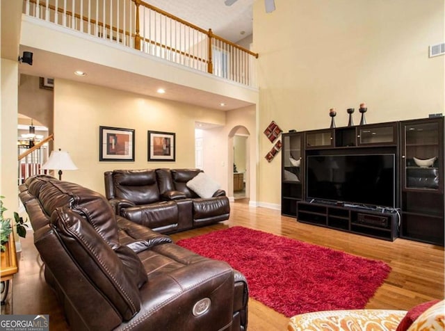 living room with light hardwood / wood-style floors and a high ceiling