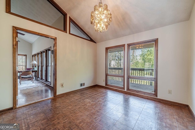 unfurnished room with an inviting chandelier, parquet flooring, and lofted ceiling