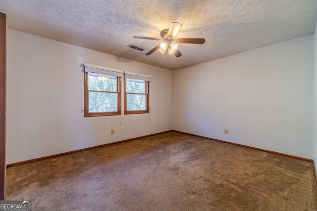 carpeted spare room featuring a textured ceiling and ceiling fan