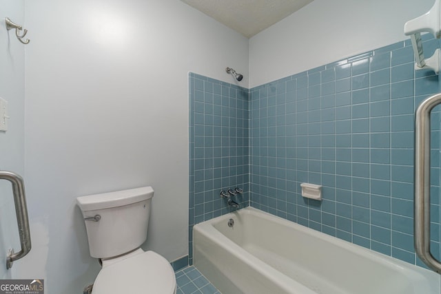 bathroom with toilet, shower / washtub combination, a textured ceiling, and tile patterned flooring