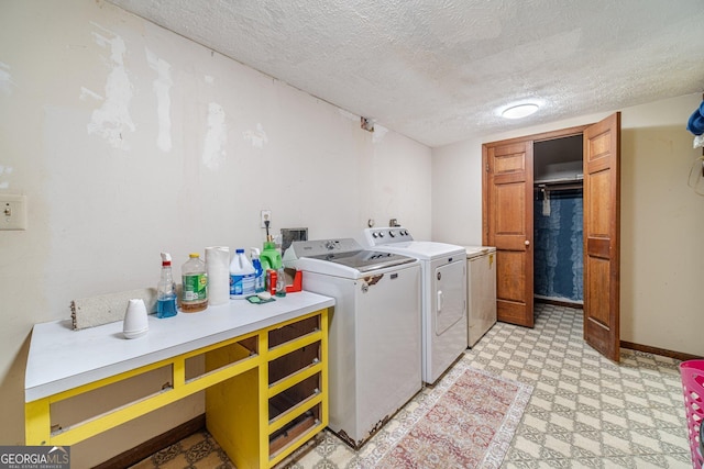 laundry room with a textured ceiling and washer and clothes dryer