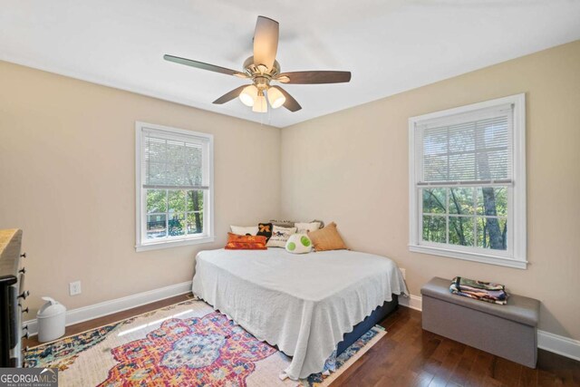 bedroom with ceiling fan, dark hardwood / wood-style floors, and multiple windows