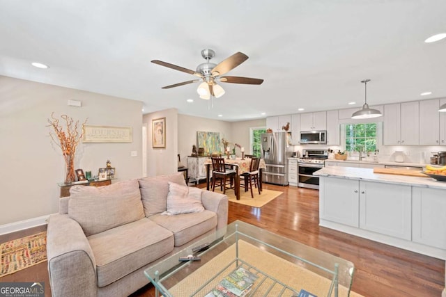 living room with light hardwood / wood-style flooring and ceiling fan