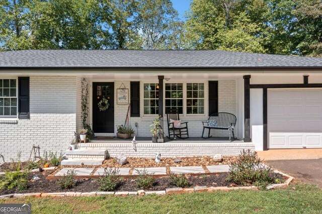 ranch-style house featuring a porch and a garage