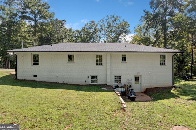 rear view of property featuring a lawn