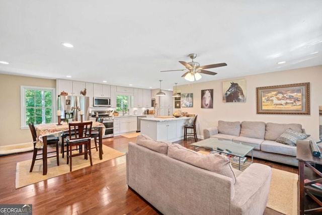 living room featuring light hardwood / wood-style floors and ceiling fan