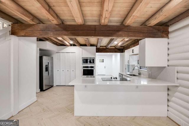 kitchen featuring kitchen peninsula, appliances with stainless steel finishes, white cabinets, and sink