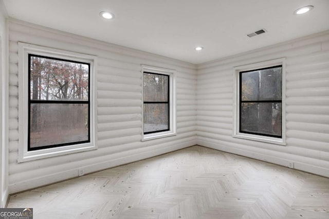 empty room with a wealth of natural light and light parquet floors