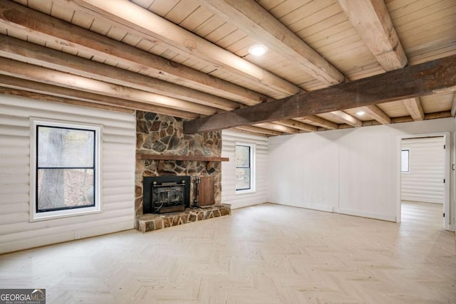 unfurnished living room with beam ceiling, light parquet floors, a wealth of natural light, and wood ceiling