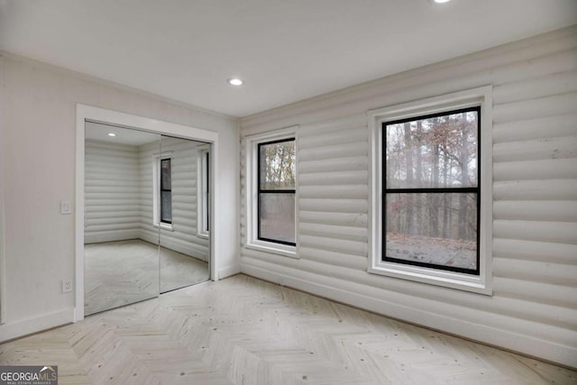 unfurnished bedroom with a closet and light parquet flooring