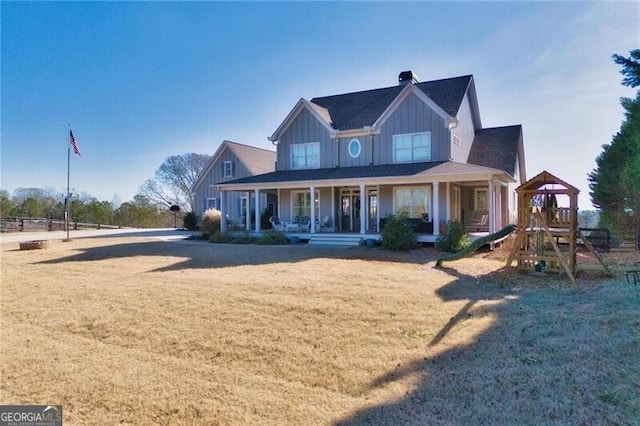 farmhouse-style home with a playground, a front lawn, and a porch