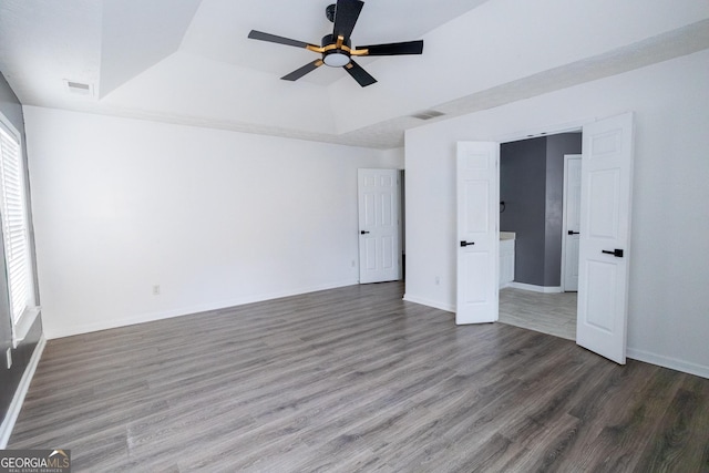 spare room featuring dark hardwood / wood-style floors, ceiling fan, and a tray ceiling