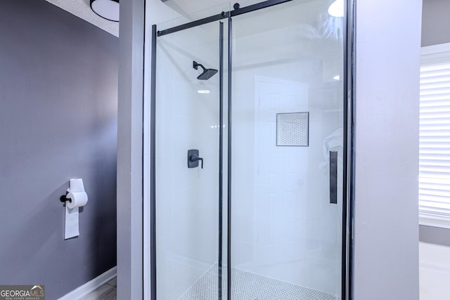 bathroom with a shower with door