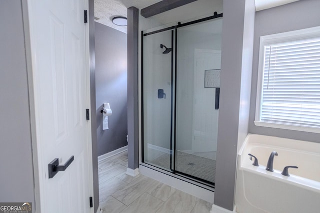 bathroom featuring a wealth of natural light, plus walk in shower, and a textured ceiling