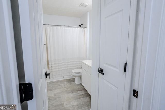 bathroom with vanity, toilet, and walk in shower