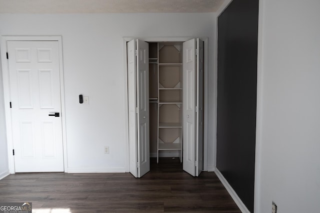 unfurnished bedroom featuring dark hardwood / wood-style flooring and a textured ceiling