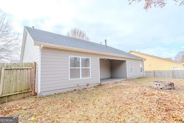 rear view of house with an outdoor fire pit