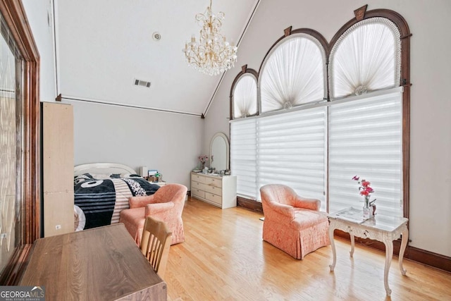 sitting room featuring high vaulted ceiling, a notable chandelier, light wood-type flooring, and a wealth of natural light