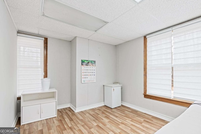 unfurnished bedroom with a paneled ceiling and light hardwood / wood-style flooring