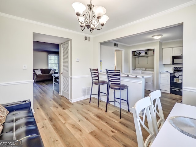 6520 Roswell Rd Unit 59, Sandy Springs, GA 30328 - dining room with a chandelier, washer and clothes dryer, light wood-type flooring, and crown molding