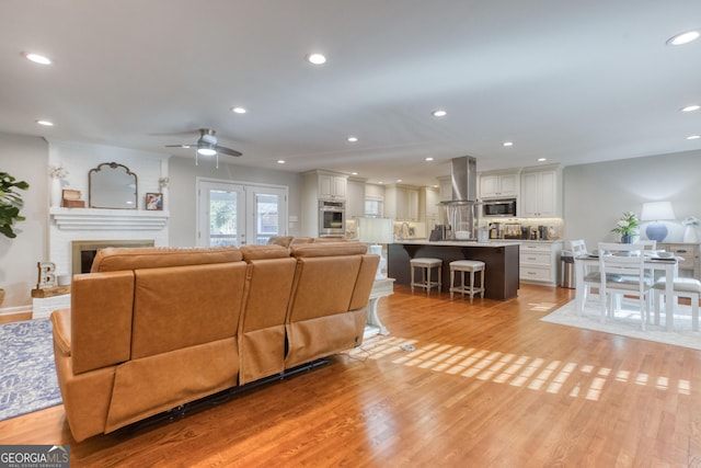 living room featuring ceiling fan and light hardwood / wood-style floors