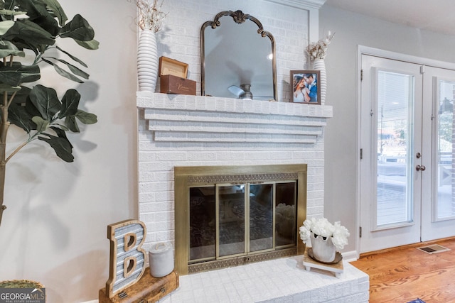 room details featuring a fireplace, french doors, and hardwood / wood-style flooring