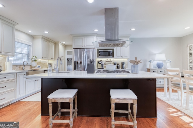 kitchen featuring decorative backsplash, stainless steel appliances, a kitchen island, and island range hood