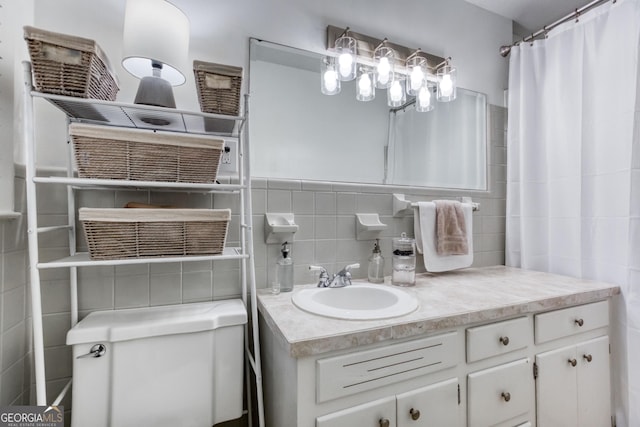 bathroom featuring vanity, toilet, and tile walls