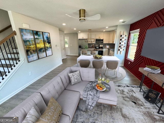 living room with a wealth of natural light, ceiling fan, and wood-type flooring