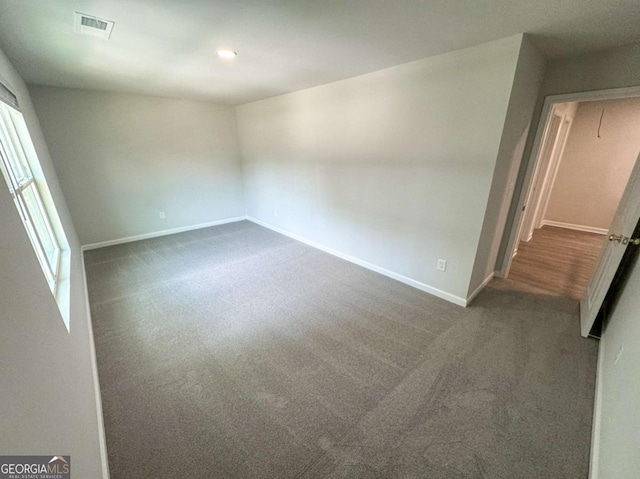 unfurnished room with dark carpet