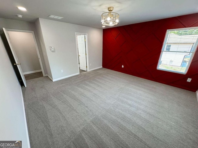 unfurnished room with carpet floors and a chandelier