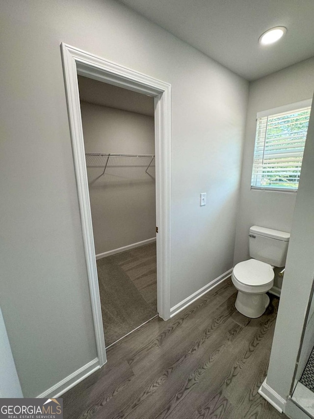 bathroom featuring wood-type flooring and toilet