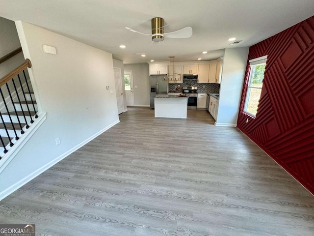 kitchen featuring white cabinets, a wealth of natural light, a center island, and appliances with stainless steel finishes