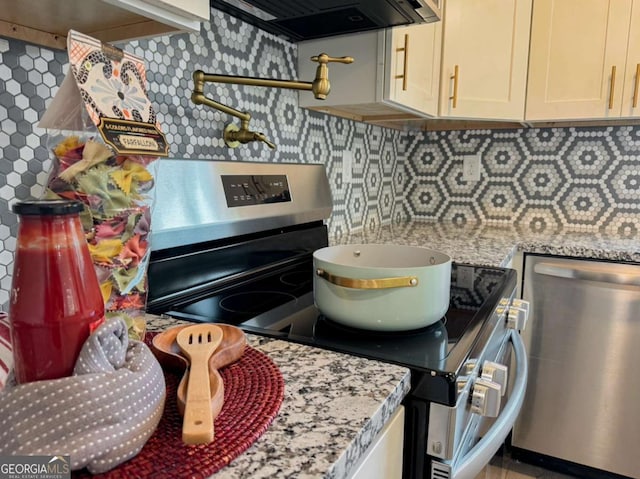 kitchen with decorative backsplash, appliances with stainless steel finishes, light stone countertops, and exhaust hood